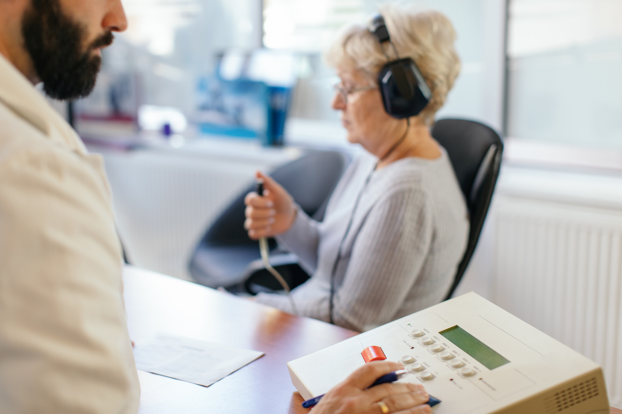 Senior-woman-undergoing-hearing-exam-from-audiologist