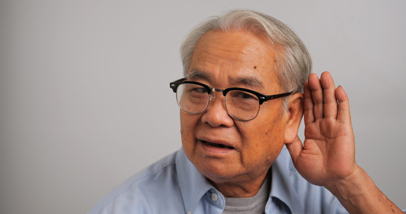 elderly man cupping ear because he is struggling to hear