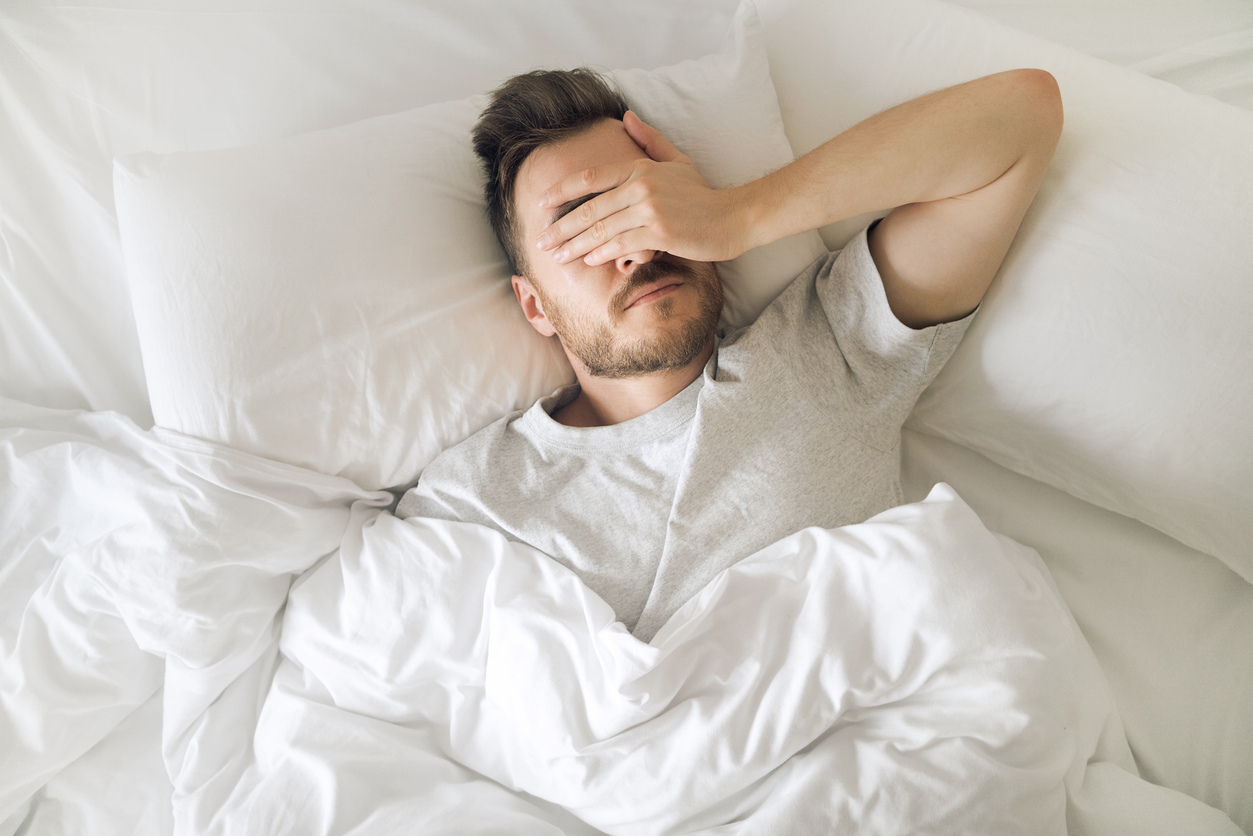 Man In Bed Struggling To Sleep