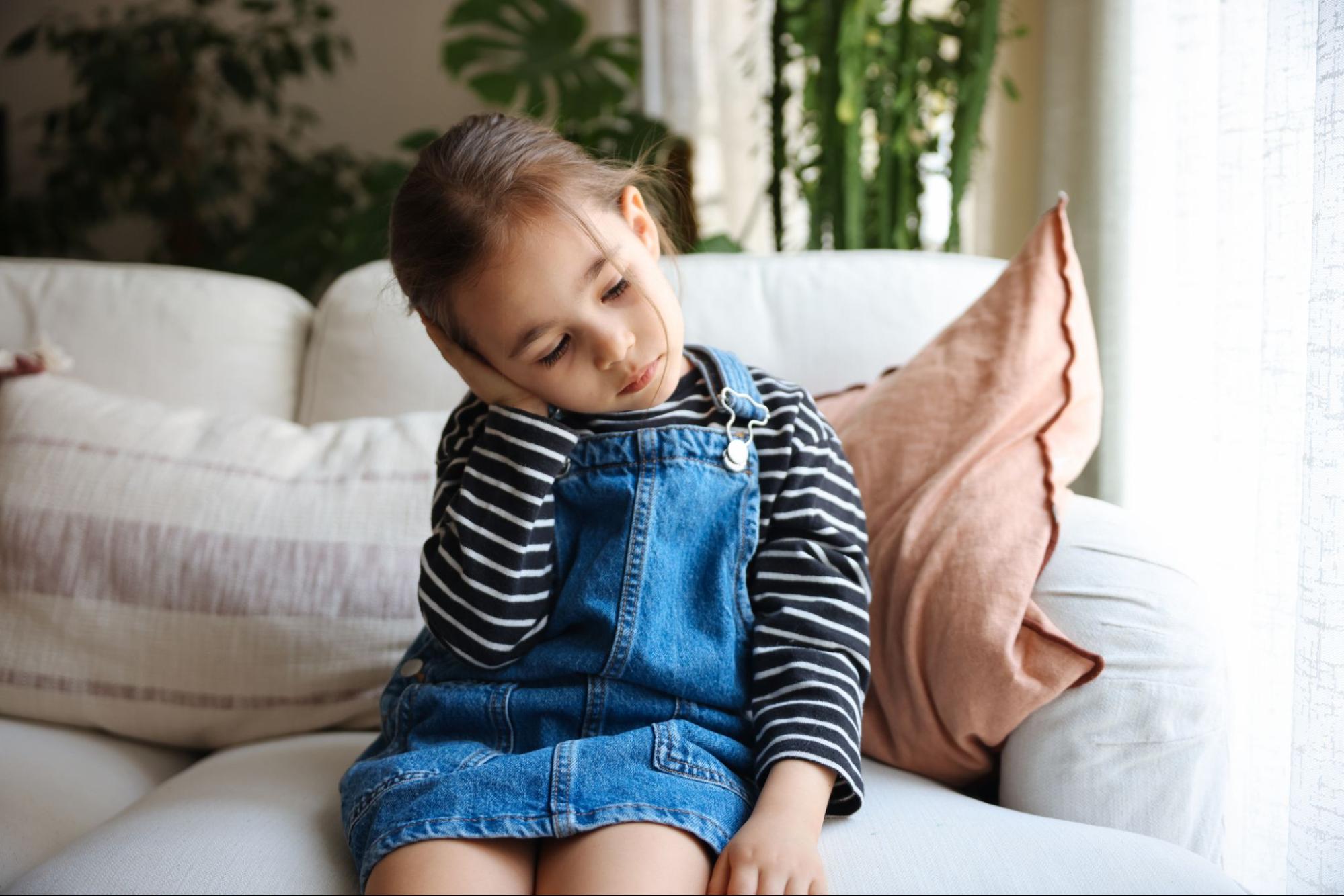 Young-girl-holding-ear-after-ear-tube-surgery