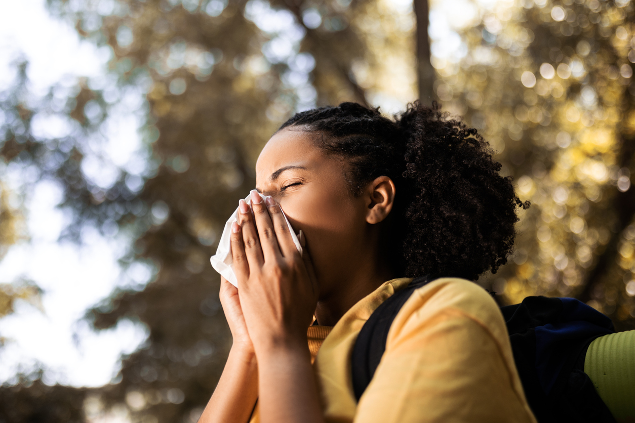 Woman-with-allergies-sneezing-outside